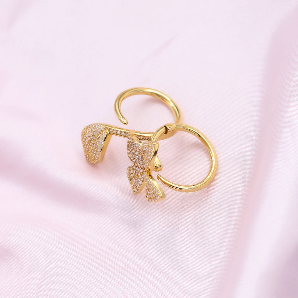 Gold keychain with bow design on a pink background