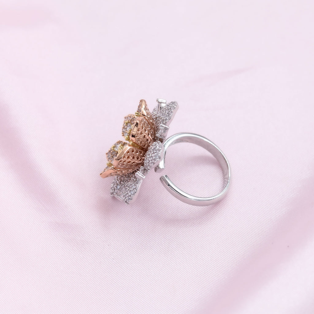 Silver ring with a decorative element on a pink background