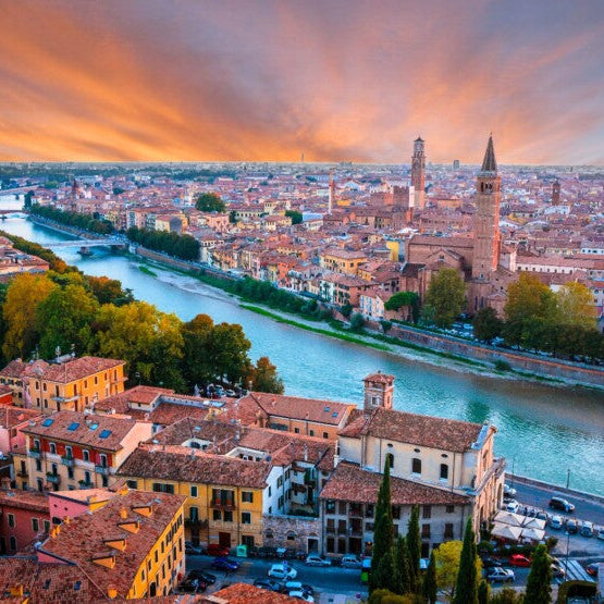 Cityscape with a river and buildings under a dramatic sky