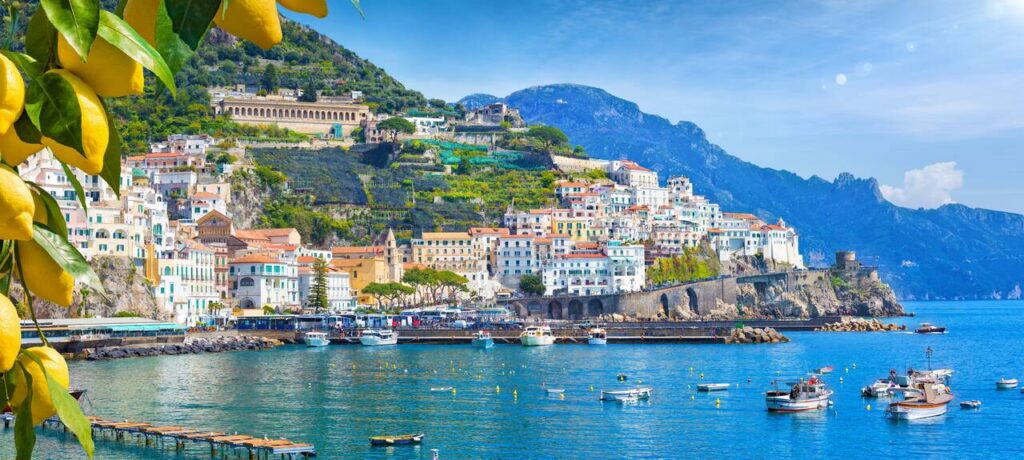 Village by the sea with boats and mountains in the background