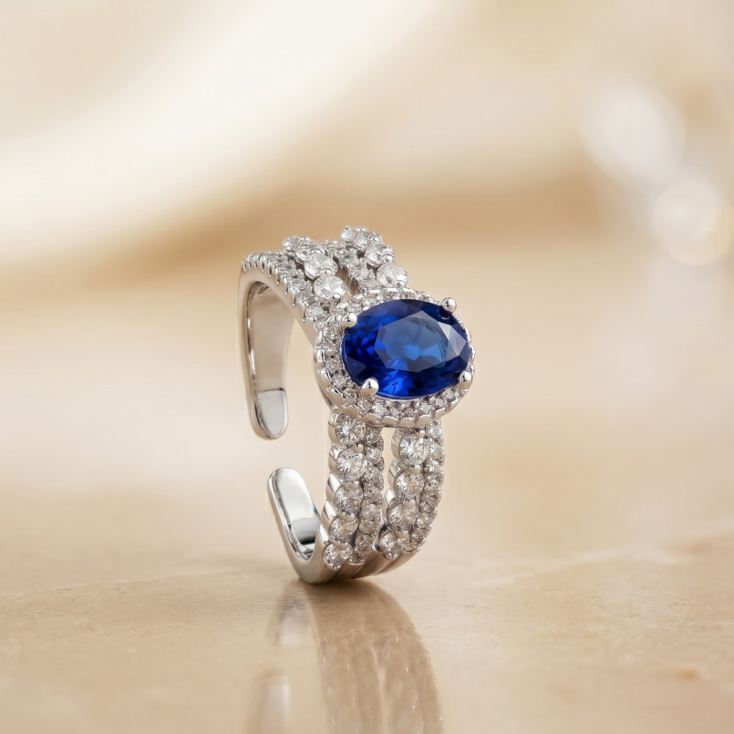 Silver ring with a blue gemstone on a beige background