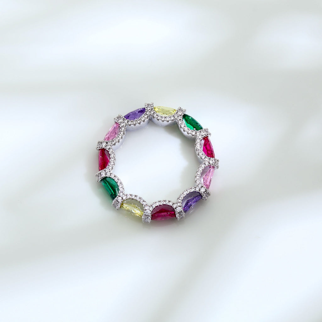 Multicolored gemstone ring with silver band on a white background